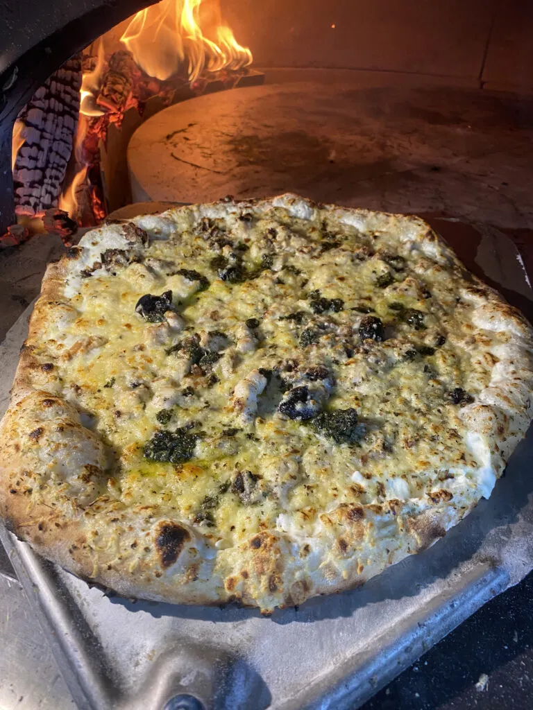 Pizza Poulet du menu de la Pizzeria Papagayo à La Ciotat, préparée avec emmental, filet de poulet, oignons et basilic, cuite au feu de bois.